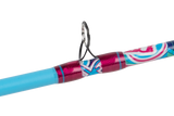 Close-up of Profishiency Wild Child spincast rod showing stainless-steel guide and vibrant pink, blue, and white thread wrap on light gray background