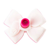 Pink-and-white plastic bow accessory with central pink cylindrical hub and small heart imprint on one petal.