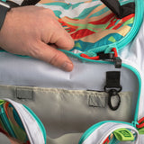 Hand opening colorful kids backpack showing interior pocket, turquoise zipper and black key clip