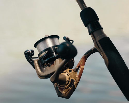 Fishing rod with reel held by a hand over water