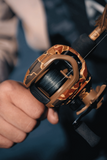 Close-up view of Retro Baitcast Reels - Clam Pack showcasing its classic-camo design and spool in hand