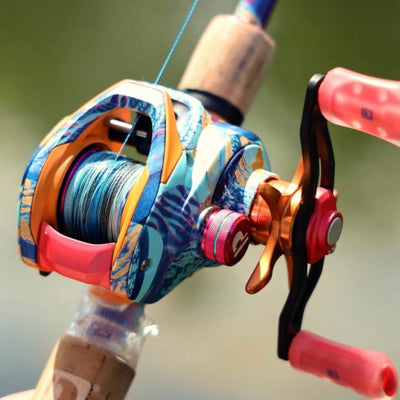 Colorful blue and orange baitcasting fishing reel mounted on a rod with braided line